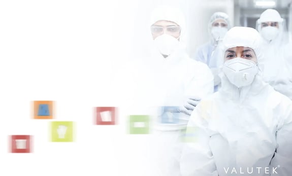 Cleanroom operators standing up wearing full cleanroom gowns.