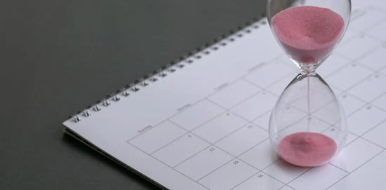A calendar with an hourglass on top.
