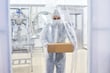 A pharmaceutical lab worker carrying box